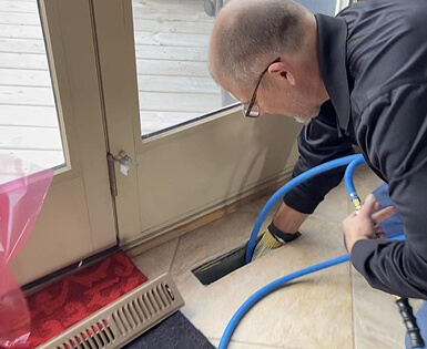 Air Duct Cleaning technician discussing the results of the HVAC system inspection with a homeowner, pointing at a report.
